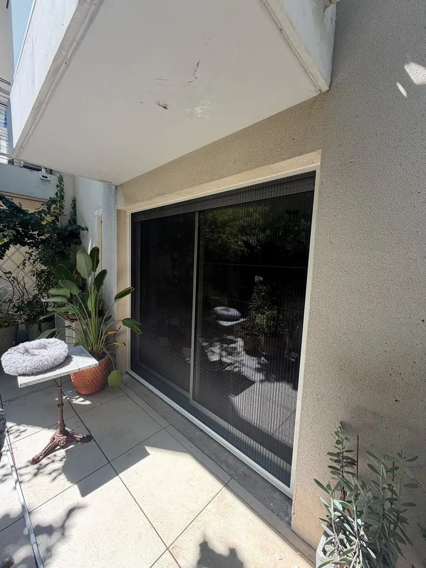 Moustiquaire plissée sur baie donnant au jardin — réalisation ALUBELLE en Provence