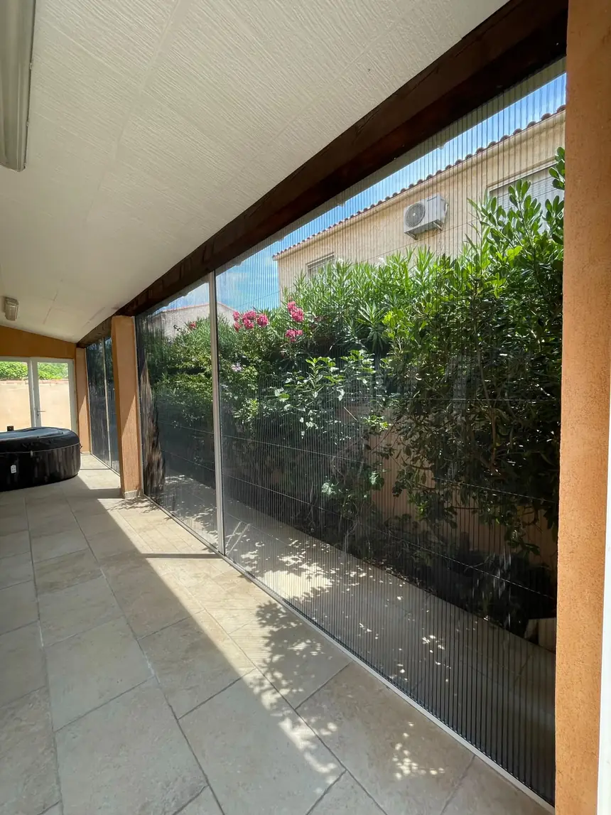 Moustiquaires plissées sur un auvent de terrasse — réalisation ALUBELLE en Provence