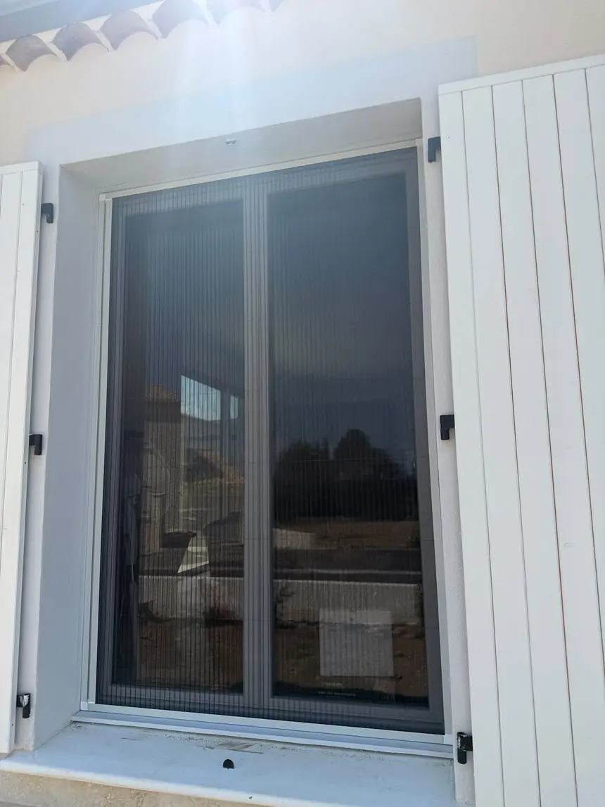 Moustiquaire plissée 2 vantaux sur fenêtre de chambre — réalisation ALUBELLE en Provence