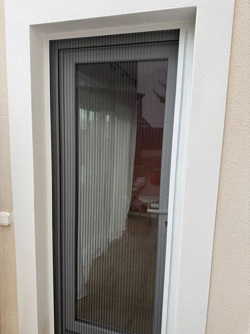 Moustiquaire plissée sur porte-fenêtre de chambre — réalisation ALUBELLE en Provence